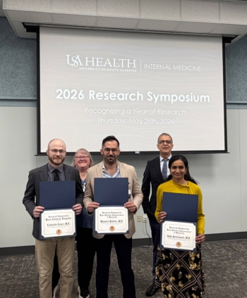 3 resident physicians holding their awards for research