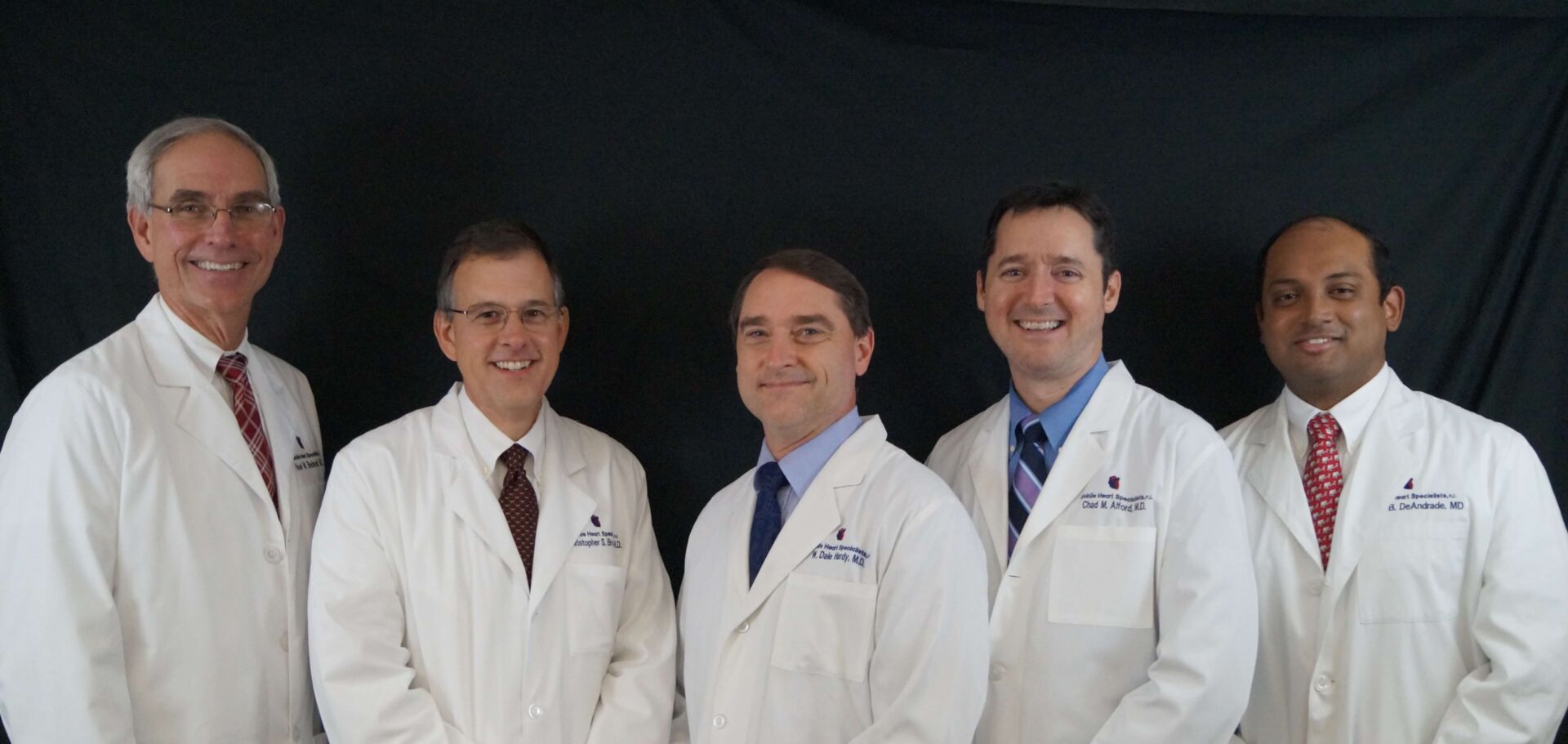 Physicians in white coats standing together. From left, Bedwell, Brown, Hardy, Alford and DeAndrade.