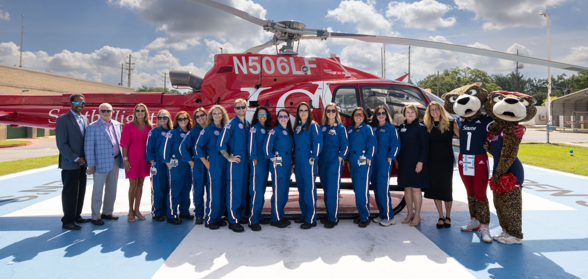 The Cub Crew team at USA Health Children’s & Women’s Hospital poses in front of a helicopter with members of USA leadership.