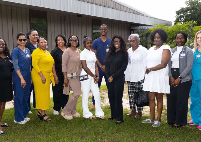 Mylaija Shavers (center, blue) surrounded by family and members of the Johnson Haynes Jr. M.D. Comprehensive Sickle Cell Center staff.