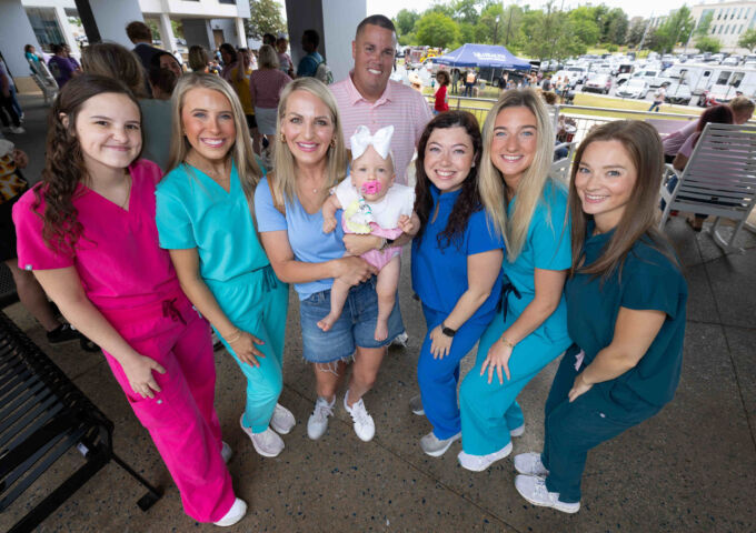 Parents and their baby pose with USA Health employees at the reunion.