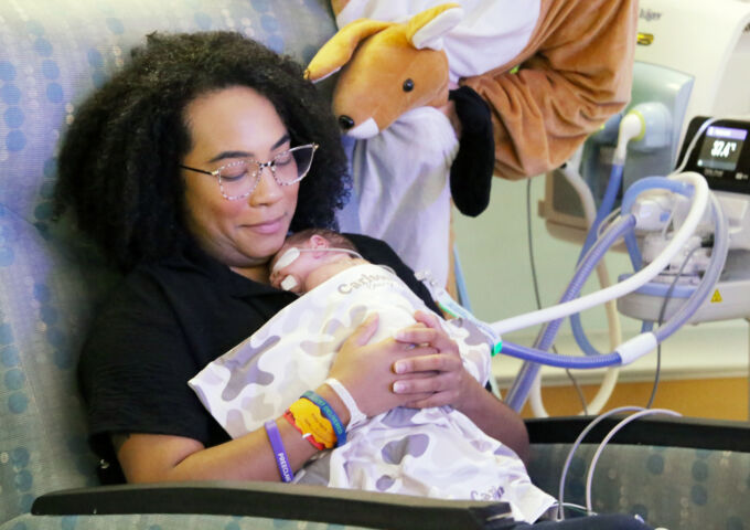 Mother snuggles with baby in NICU