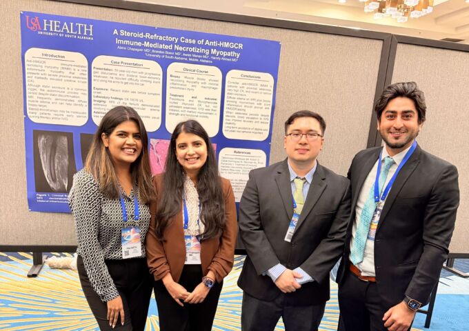Resident physicians stand in front of poster