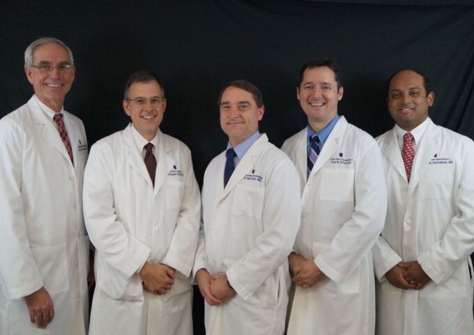 Physicians in white coats standing together. From left, Bedwell, Brown, Hardy, Alford and DeAndrade.