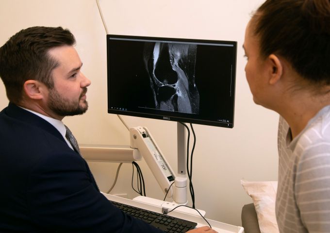 Brad Clay, M.D., discusses a scan with a patient.