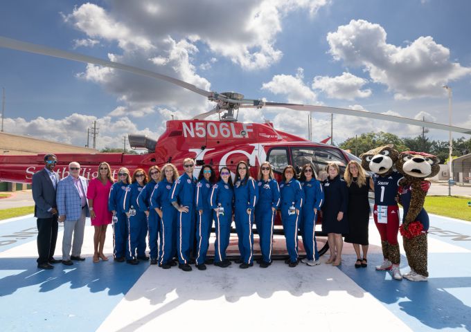 The Cub Crew team at USA Health Children’s & Women’s Hospital poses in front of a helicopter with members of USA leadership.