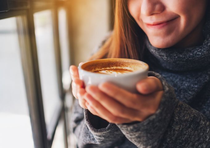 A woman enjoys a warm cup of coffee.