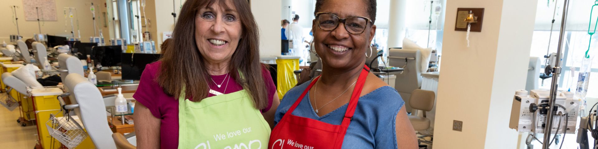 USA Health Mitchell Cancer Center volunteers Debby Lowe (left) and Rhonda Agnew pose for a photo in their new aprons.