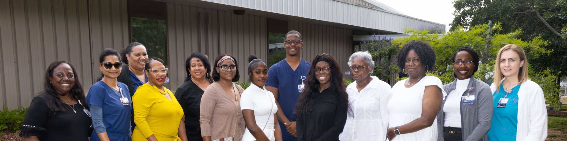 Mylaija Shavers (center, blue) surrounded by family and members of the Johnson Haynes Jr. M.D. Comprehensive Sickle Cell Center staff.