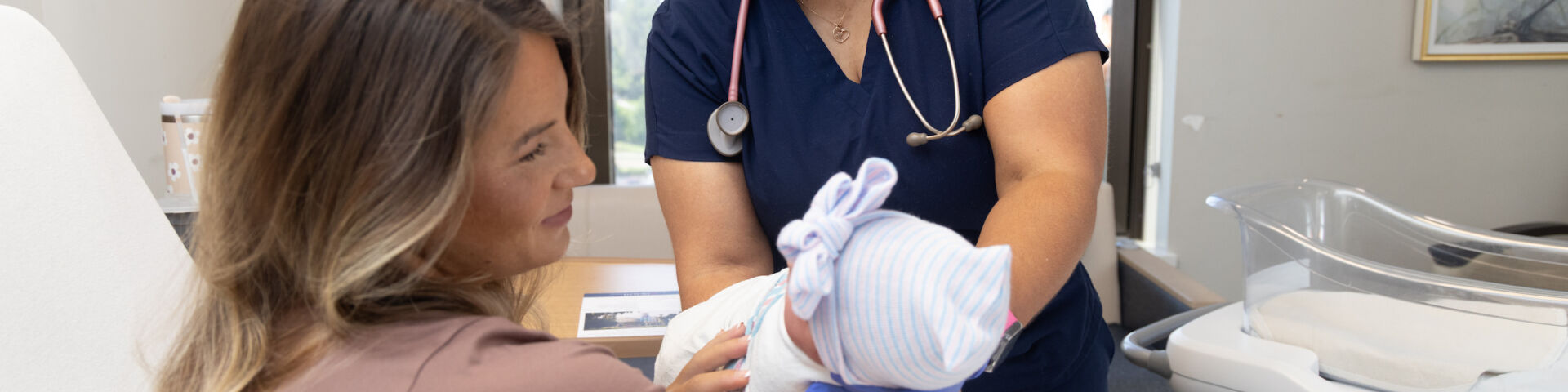 Children’s & Women’s Hospital - nurse handing baby to mother