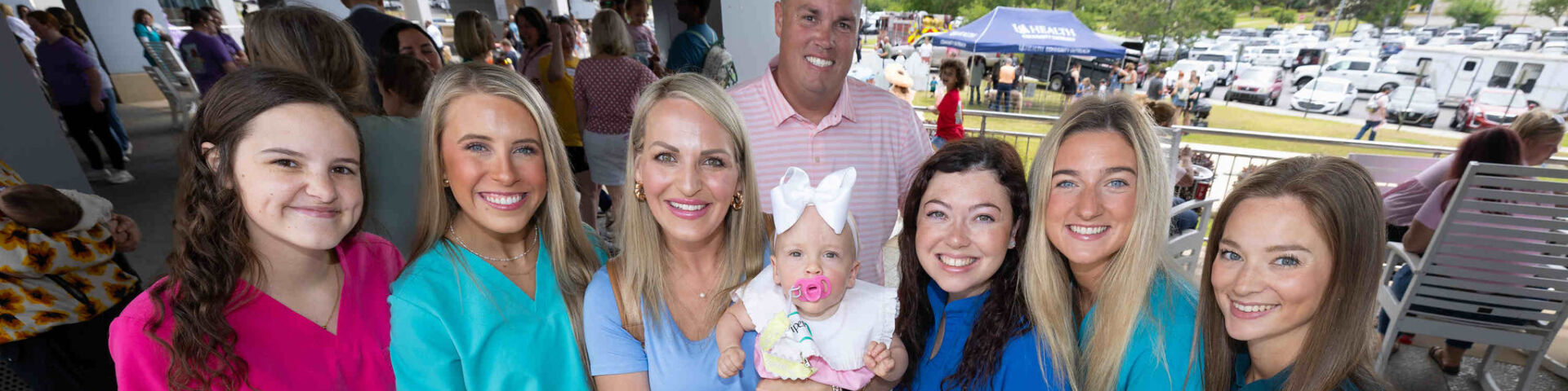Parents and their baby pose with USA Health employees at the reunion.
