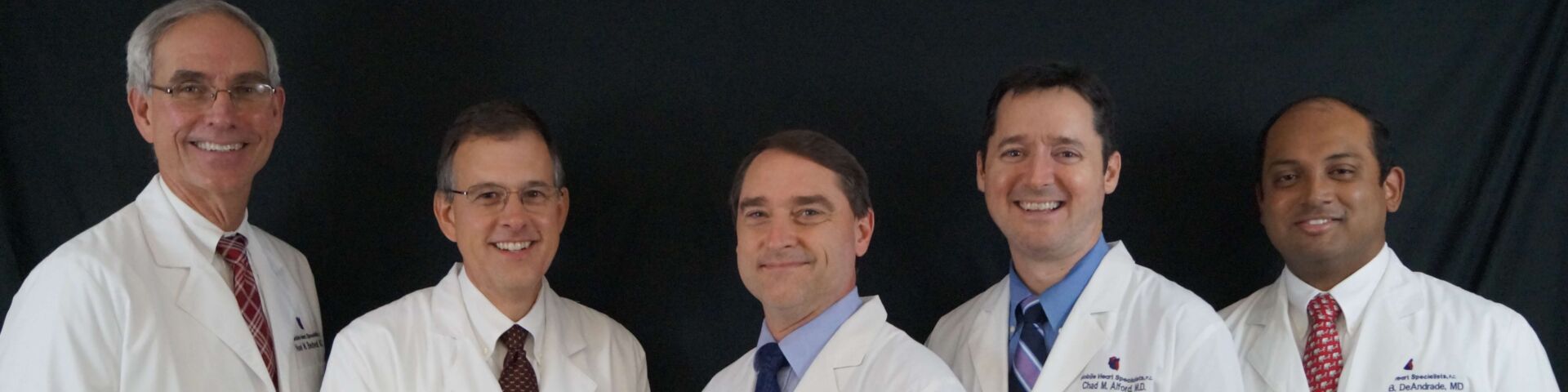 Physicians in white coats standing together. From left, Bedwell, Brown, Hardy, Alford and DeAndrade.