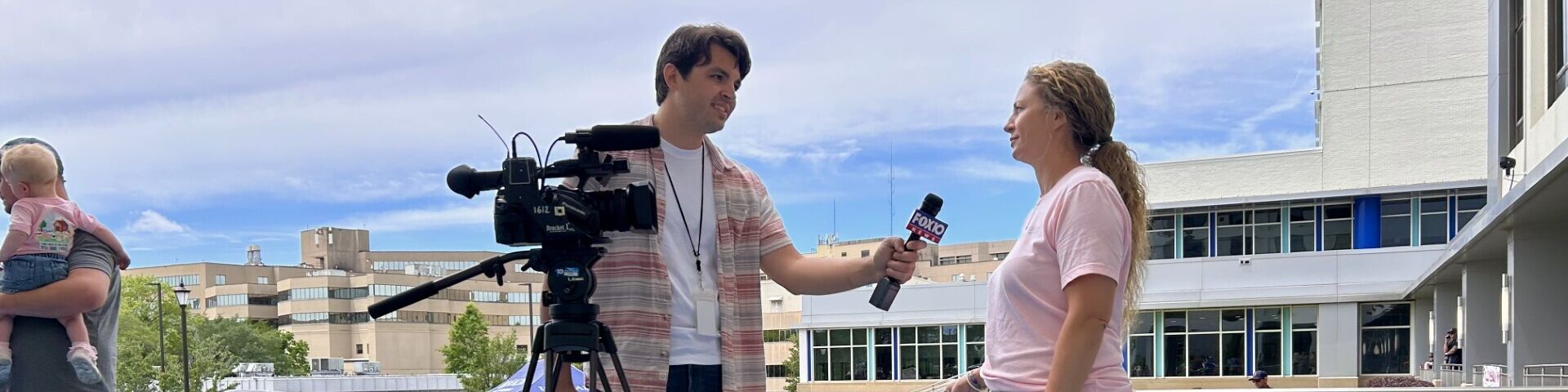 A USA Health employee is interviewed by a television reporter.